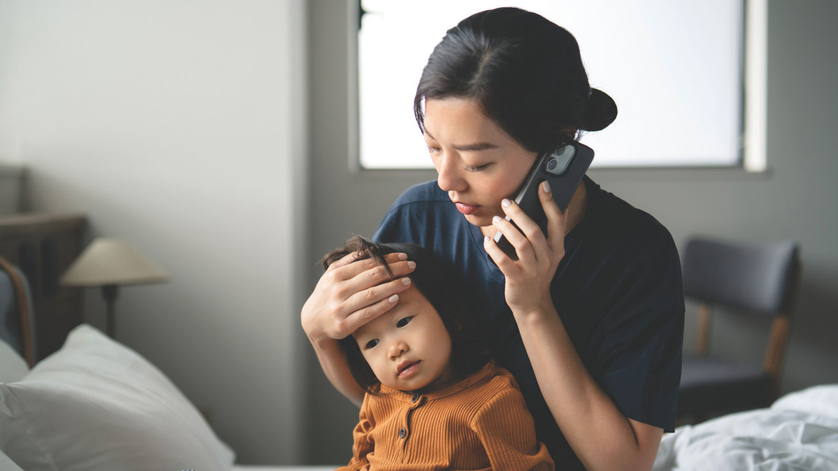 Worried young Asian mother and her sick daughter having online medical consultation, taking advice from doctor on phone call. Children's health and illness. Telehealth and telemedicine with technology concept